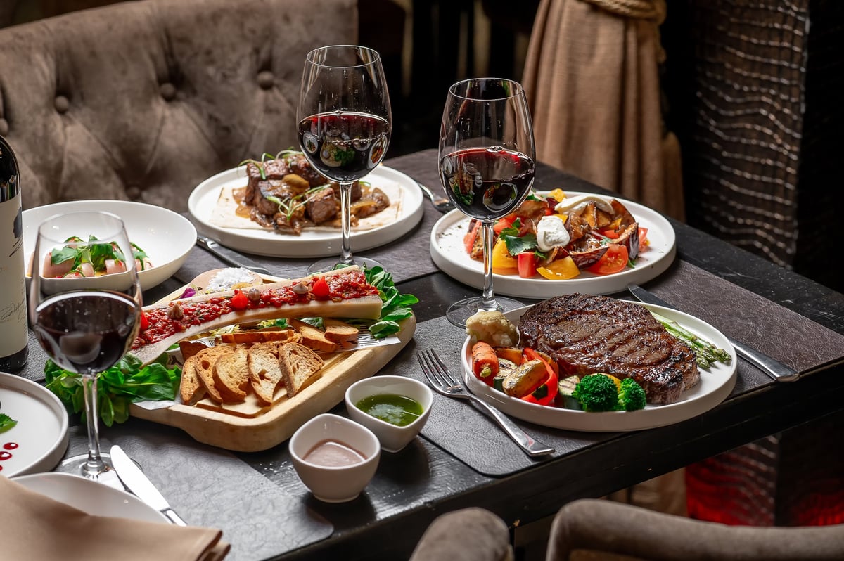 Guests enjoying a fine dining meal with wine at an Everest Group restaurant
