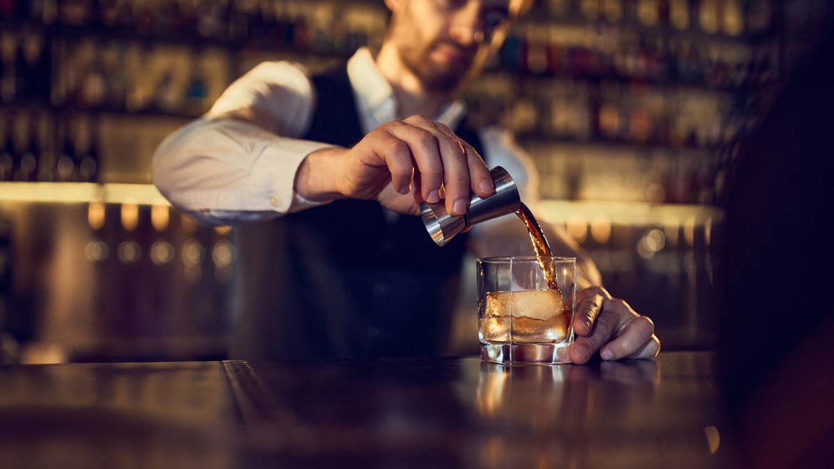 Bartender pouring a crafted cocktail at the bar at TABOO, Wan Chai