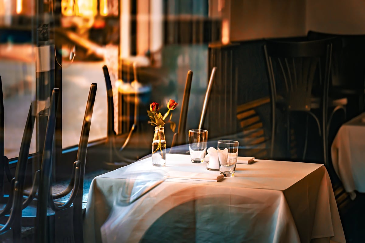Elegant restaurant table set for two in a dark dining room